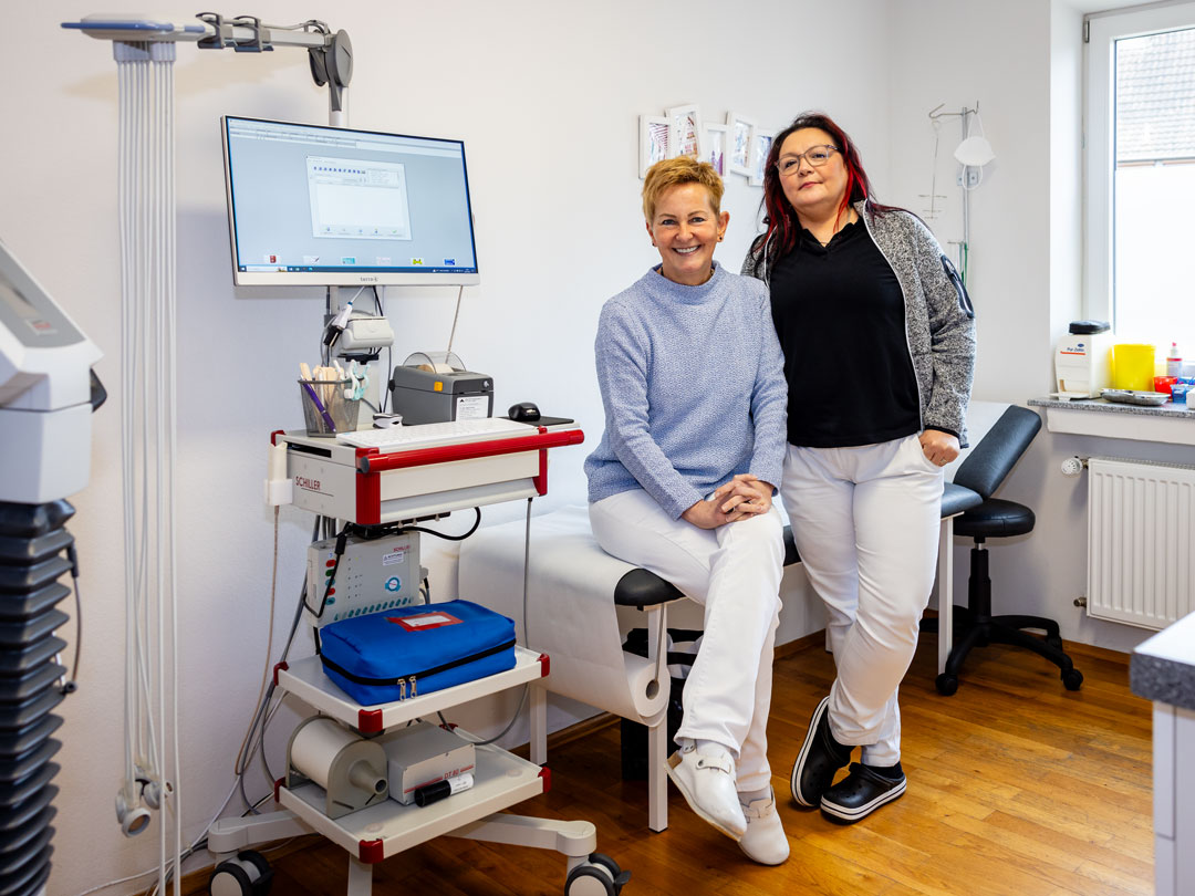 Angelika Sailer und Sonja Pohl in einem Behandlungszimmer der Hausarztpraxis Aachen Soers.